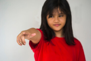 A young beautiful girl pointing with her index finger.