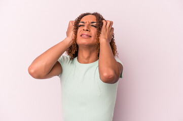 Fototapeta premium Young latin transsexual woman isolated on pink background crying, unhappy with something, agony and confusion concept.