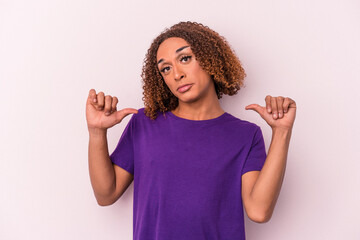 Young latin transsexual woman isolated on pink background feels proud and self confident, example to follow.