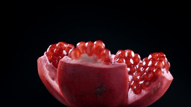 Video of rotating pomegranate seeds on black background