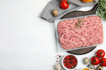 Raw chicken minced meat and ingredients on white wooden table, flat lay. Space for text