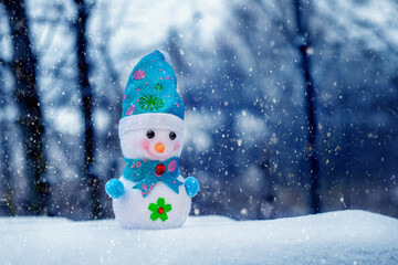 Snowman in the forest during a snowfall. Christmas and New Year greeting card