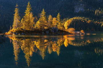 Autumn colors in fall at lake eibsee. Small islands on the lake with fall colours and beautiful reflections