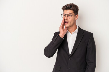 Young business caucasian man isolated on white background is saying a secret hot braking news and looking aside