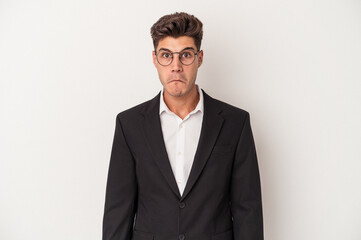 Young business caucasian man isolated on white background shrugs shoulders and open eyes confused.