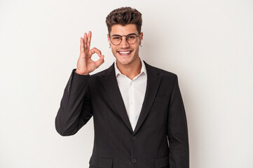 Young business caucasian man wearing headphones isolated on white background cheerful and confident showing ok gesture.