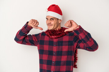 Young caucasian man celebrating Christmas isolated on white background feels proud and self confident, example to follow.