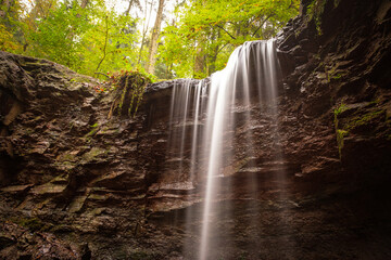 Obraz premium Waterfall cascade is flowing over a rock