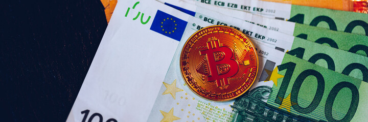 Golden bitcoin over Euro money. Bitcoin cryptocurrency. Crypto currency concept. Bitcoin with euro bills. Bitcoins stacked on euro banknotes.