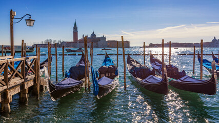 Fototapeta na wymiar Gondolas moored near San Marco square across from San Giorgio Maggiore island in Venice, Italy. Gondolas were once the main form of transportation around the Venetian canals. Venice, Italy.