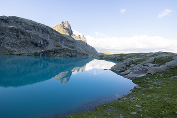 Wonderful view over a beautiful alpine lake in Switzerland called Schottensee. Epic sunrise over a perfect blue lake.