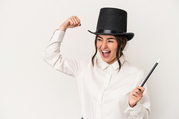 Young magician woman holding a wand isolated on white background raising fist after a victory, winner concept.