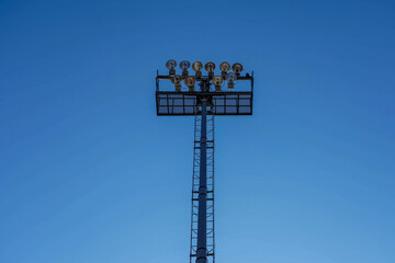 Naklejka premium Photo of a lighting mast on a football field against a blue clear sky