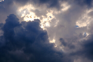 beautiful stormy skies with sun rays breaking through white and dark clouds