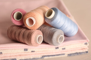 Set of color sewing threads on light grey table, closeup