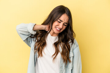 Young caucasian woman isolated on yellow background suffering neck pain due to sedentary lifestyle.