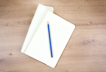 Empty notepad with pencil on wooden table