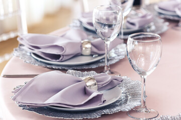 catering table set service with silverware, purple napkin and glassware at restaurant.