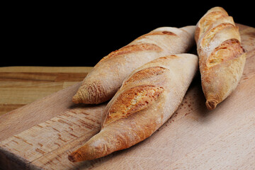 three mini baguette on wooden board closeup