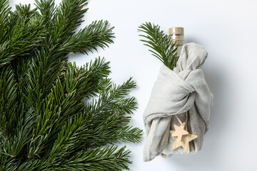 Zero waste Merry Christmas winter gift wrapping, bottle in Japanese furoshiki style in linen...