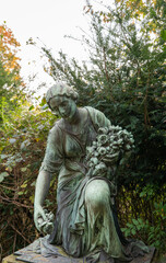 eine trauernde Frau mit Blumen im Arm