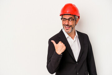 Middle age architect caucasian man isolated on white background  points with thumb finger away, laughing and carefree.