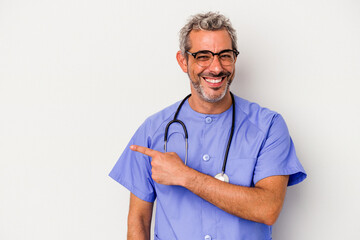 Middle age nurse caucasian man isolated on white background  smiling and pointing aside, showing something at blank space.