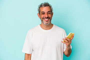 Middle age caucasian man holding a mobile phone isolated on blue background  happy, smiling and cheerful.