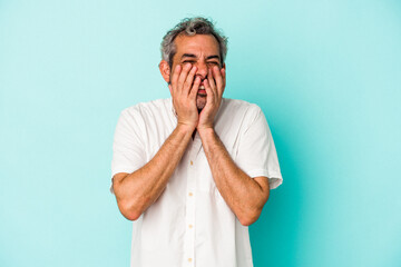 Middle age caucasian man isolated on blue background  laughing about something, covering mouth with hands.