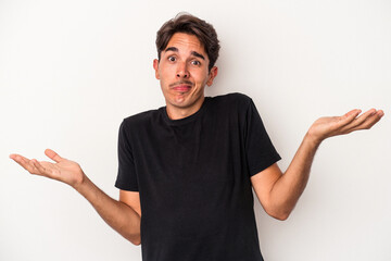 Young mixed race man isolated on white background doubting and shrugging shoulders in questioning...