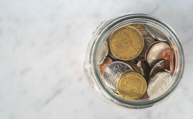 Conceptual Savings - Jar full of New Zealand Coins from Above with Copy Space