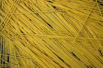 Raw spaghetti on a black background. Yellow long spaghetti. Italian cuisine concept