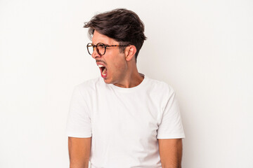 Young mixed race man isolated on white background shouting very angry, rage concept, frustrated.