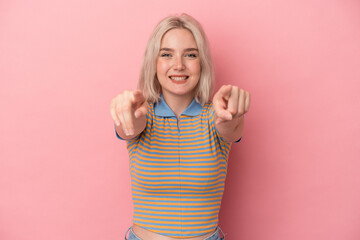 Young caucasian woman isolated on pink background cheerful smiles pointing to front.