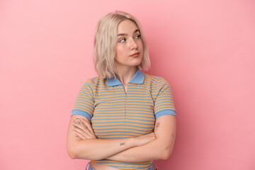 Young caucasian woman isolated on pink background dreaming of achieving goals and purposes