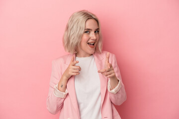 Young caucasian woman isolated on pink background pointing to front with fingers.