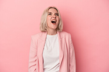 Young caucasian woman isolated on pink background shouting very angry, rage concept, frustrated.