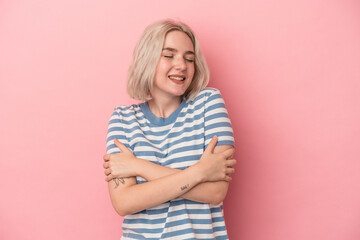 Young caucasian woman isolated on pink background laughing and having fun.