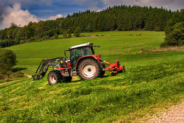 Fototapeta premium Traktor mit Mähwerk beim Silageschnitt