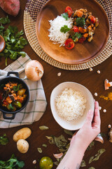 vegan food on the table rice and vegetables carrots sweet potato tomatoes coriander turmeric onions and chickpeas healthy food dish messy table plant-based diet