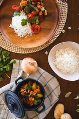 vegan food on the table rice and vegetables carrots sweet potato tomatoes coriander turmeric onions and chickpeas healthy food dish messy table plant-based diet