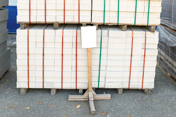 Hollow silicate brick in the construction market on the street, with an empty sign for the price