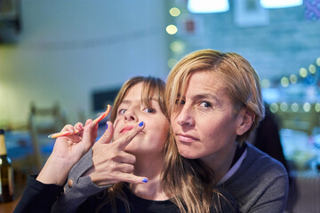 Beautiful older woman looking proud, confident and powerful, gesturing defiantly, showing strength, success or victory, with her daughter