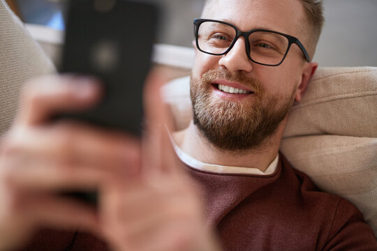 Content man taking selfie on smartphone at home