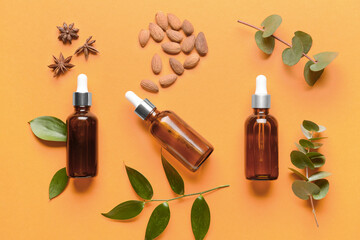 Bottles of essential oils on color background