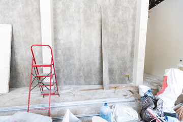 The wall of the building is covered with fresh plaster and surrounded by construction. Background.