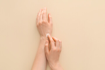 Woman applying natural hand cream on light background