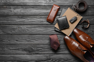 Set of stylish male accessories on dark wooden background
