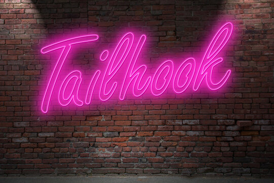 Neon Tailhook lettering on Brick Wall at night
