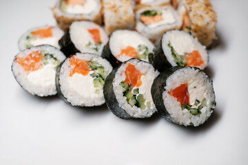 Sushi set with salmon, tuna and cream cheese close-up. Traditional Japanese cuisine on white background.